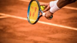 close up photo of person holding tennis racket and ball