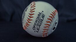 white and orange official league baseball on black textile