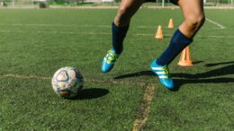 man in blue sneakers playing football